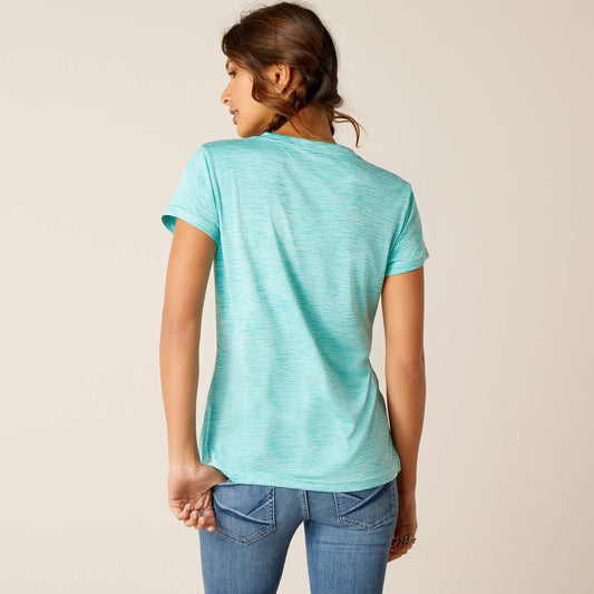 Rear view of a young woman wearing a light blue ariatv-neck top with short sleeves, standing against a neutral background