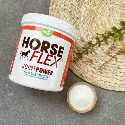 A pot of Horseflex JointPower powder against a grey backround ontop of a rattan rug with a smal wooden bowl filled with white powder sample